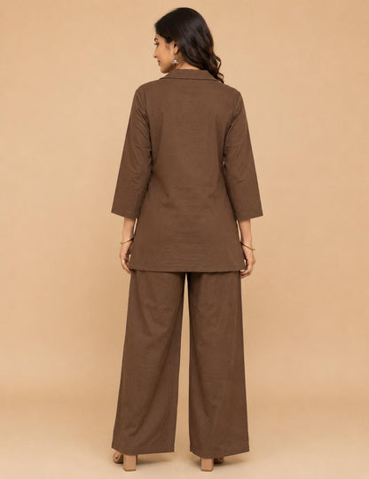 May include: A solid brown two-piece set consisting of a long-sleeved tunic with a collared neckline and matching wide-leg trousers. The tunic features three-quarter length sleeves and a straight hemline, while the trousers have a loose fit.